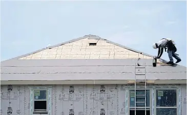  ?? AP ?? A constructi­on worker puts down roofing paper on a new home in Houston.