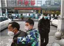  ?? Ng Han Guan / Associated Press ?? A man carries a child past the Hubei Province Xinhua Hospital during a visit by a WHO team in Wuhan, China.