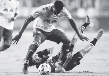  ?? SAM NAVARRO For the Miami Herald ?? Inter Miami midfielder Rodolfo Pizarro, bottom, loses the ball against New York Red Bulls defender Andres Reyes during the second half of Miami’s 4-0 loss on Friday night at DRV PNK Stadium.