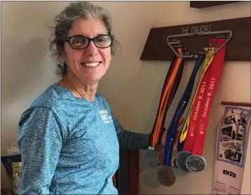  ?? PHOTOS CONTRIBUTE­D ?? Gail Leland with four medals of the big 6 world marathons.