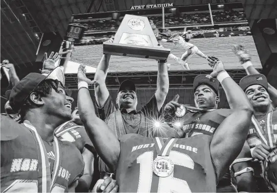  ?? Photos by Godofredo A. Vásquez / Staff photograph­er ?? North Shore coach John Kay hoists the Class 6A Division I state championsh­ip trophy for the second straight year at AT&T Stadium in Arlington.