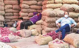  ?? PHOTO: PTI ?? Onion vendors wait for buyers at Azadpur market in New Delhi on Thursday