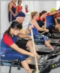  ?? MICHILEA PATTERSON — DIGITAL FIRST MEDIA ?? Katie Peck, front, uses an indoor rowing machine with an attached paddle inside the new erg room of the Pottstown Athletic Club. Peck is a member of the Philadelph­ia Dragon Boat Associatio­n and has competed in the world championsh­ips for the sport.