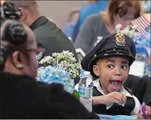  ?? ?? Michael J. McKinney Jr., 6, makes a face while wearing the hat of his father, Ledyard Police Sgt. Michael McKinney, during the event.