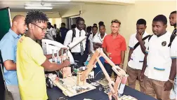  ??  ?? Prospectiv­e students of UTech Jamaica watch in awe as a hydraulic robotic arm attempts to lift a plastic cup in the air at Open House 2016.