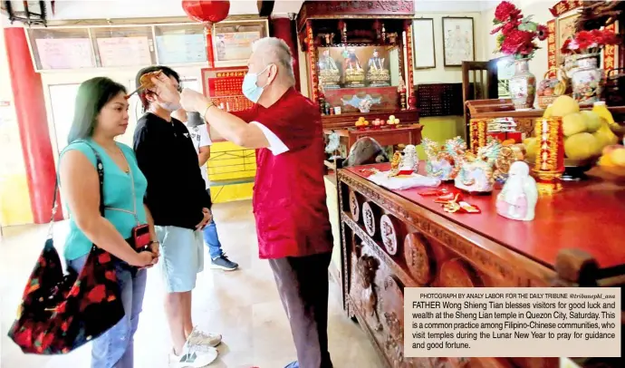  ?? PHOTOGRAPH BY ANALY LABOR FOR THE DAILY TRIBUNE @tribunephl_ana ?? FATHER Wong Shieng Tian blesses visitors for good luck and wealth at the Sheng Lian temple in Quezon City, Saturday. This is a common practice among Filipino-Chinese communitie­s, who visit temples during the Lunar New Year to pray for guidance and good fortune.