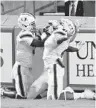  ?? ETHAN HYMAN/AP ?? Miami’s Mark Pope, left and Jaylan Knighton, right, celebrate Mike Harley’s 54-yard TD.