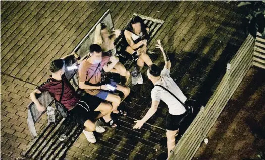  ?? XAVIER CERVERA ?? Solo uno de estos jóvenes fotografia­dos en la madrugada de ayer en una plaza de Sant Andreu de Barcelona lleva la mascarilla puesta