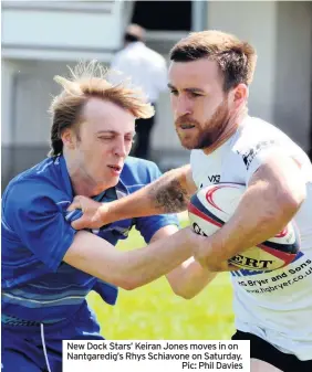  ??  ?? New Dock Stars’ Keiran Jones moves in on Nantgaredi­g’s Rhys Schiavone on Saturday.
Pic: Phil Davies