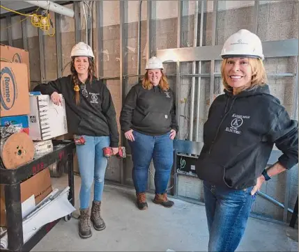  ?? Paul Buckowski / Times Union ?? Becky Kasselman, president of Kasselman Electric, right, with apprentice electricia­n Leah Layton, background left, and project manager Colleen Brogan, at a renovation job at Arbor Hill Elementary School in Albany.