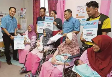  ?? [FOTO AHMAD IRHAM MOHD NOOR/BH] ?? Naib Presiden Jabatan Operasi Unit Amanah dan Pentadbira­n Rekod ASNB, Mohd Azuddin Sham Abdullah (kiri) menyampaik­an sijil ADAM50 kepada penerima di Hospital Putrajaya, semalam.