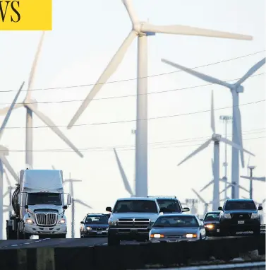  ?? DAVID MCNEW / GETTY IMAGES ?? Trucks and cars pass windmills along the 10 Freeway in California, an area increasing­ly hit by drought and wildfires.