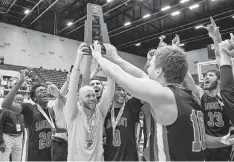  ?? AL DIAZ adiaz@miamiheral­d.com ?? Sagemont basketball coach David Roe hoists the championsh­ip trophy with players after defeating Orlando Christian Prep on Friday in Lakeland.