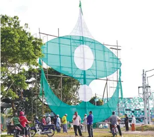  ?? BERNAMAPIX ?? ... People looking at a giant kite with the PAS logo in Kampung Kedai Buluh, Terengganu.