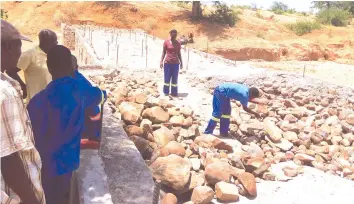  ??  ?? Mutema youths work on the Nyunga river bridge in Chipinge