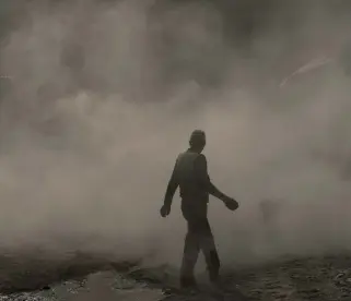  ??  ?? A man walks amid a cloud of dust as a bulldozer removes debris from destroyed shops in the Old City of Mosul. (AP/File photo)