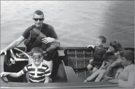  ?? Norman family via AP ?? This July 1965 photo provided by the Norman family shows Dr. Richard Norman in his boat on the St. Lawrence River with sons David and Peter, nephew John and cousins.