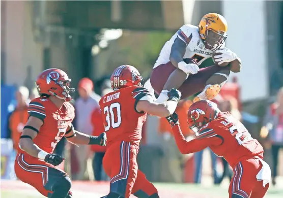  ?? RICK BOWMER/AP ?? Arizona State running back Kalen Ballage (center) jumps in front of Utah's Julian Blackmon (23) and Cody Barton (30) in the second half of Saturday’s game in Salt Lake City.