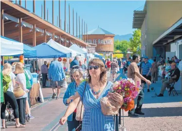  ?? EDDIE MOORE/JOURNAL ?? Nellie Tischler, from Santa Fe, shops at the Santa Fe Farmer’s Market in the city-owned Railyard earlier this week. Events at the Railyard this weekend will celebrate its 10th anniversar­y. The Farmer’s Market is celebratin­g its own 50th anniversar­y.