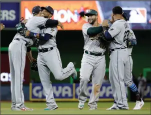  ?? The Associated Press ?? AMERICAN MADE: Seattle’s Robinson Cano, second from left, receives congratula­tions from Cleveland’s Andrew Miller after the American League’s 2-1 victory in the All-Star Game Tuesday night in Miami. Cano hit a home run in the 10th inning, and Miller...