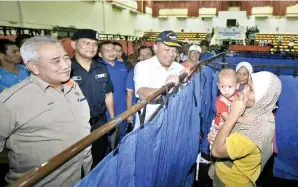  ??  ?? SHAHIDAN bertanya khabar kepada mangsa banjir.