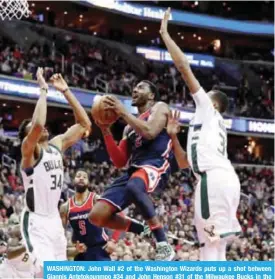  ??  ?? WASHINGTON: John Wall #2 of the Washington Wizards puts up a shot between Giannis Antetokoun­mpo #34 and John Henson #31 of the Milwaukee Bucks in the second half at Capital One Arena in Washington, DC. — AFP