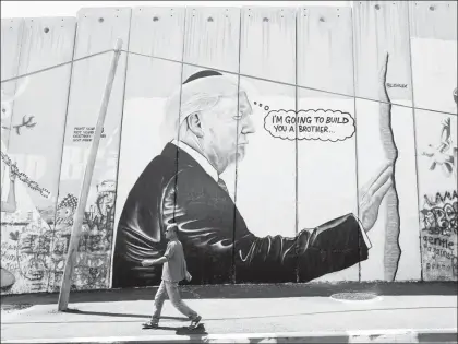  ??  ?? Un mural parecido al trabajo de la figura del arte callejero británico Banksy representa al presidente de Estados Unidos, Donald Trump, en el muro construido en Cisjordani­a ■ Foto Ap