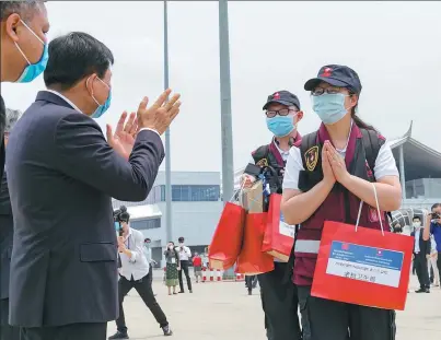  ?? KAIKEO SAIYASANE / XINHUA ?? Lao Health Minister Bounkong Sihavong (second from the left) bids farewell to the returning Chinese medical expert team at the Wattay Internatio­nal Airport in Vientiane, the country’s capital, on Sunday.