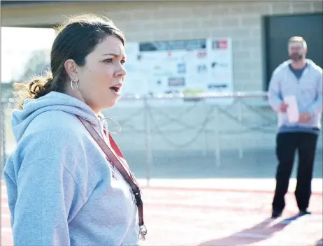  ?? TIMES photograph by Annette Beard ?? Coach Heather Wade and coach Jake Meyers watch for track runners to cross the finish line as they practice Monday.