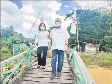  ?? — Photo by Ukas ?? Sikie and his wife Datin Melia Gelen on their way to meet and greet the constituen­ts in Kakus.