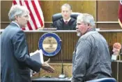  ?? STAFF PHOTO BY DAN HENRY ?? Defense attorney Lee Davis, left, moves to shake Samuel Edward Reeves’ hand before Reeves is taken into custody. Reeves pleaded guilty to voluntary manslaught­er before Judge Tom Greenholtz in the 28-year-old cold case killing of James “Richard” Layne...