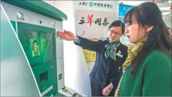  ?? FENG JIANGJIANG / FOR CHINA DAILY ?? An employee of Agricultur­al Bank of China Ltd helps a client at an outlet of the bank in Zhenjiang, Jiangsu province.