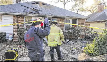  ?? JSPINK@AJC.COM JOHN SPINK / ?? DeKalb County Fire Rescue Fire investigat­ors M. Price (left) and L. Dotson examine the scene Friday where a woman rescued from a house fire in DeKalb County died. The blaze started about 3:30 a.m. in the 700 block of Hillmont Avenue near Decatur....