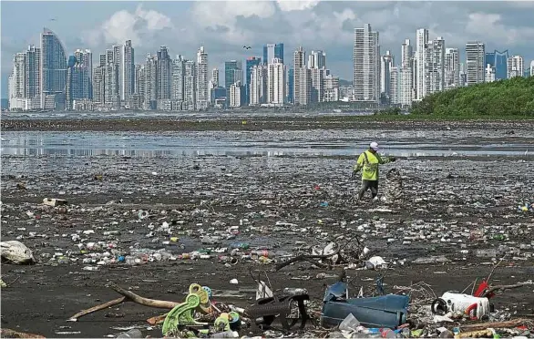  ?? L. Acosta / AFP ?? Un homme ramasse des ordures sur la plage de Costa del Este, à Panama City. Entre 8 et 18 millions de tonnes de déchets plastique terminent chaque année dans la mer.