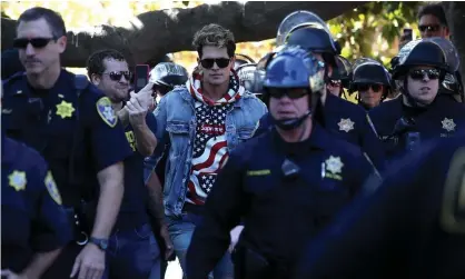  ??  ?? Milo Yiannopoul­os is escorted by police officers after speaking during a free speech rally on 24 September 2017 in Berkeley, California. Photograph: Justin Sullivan/Getty Images