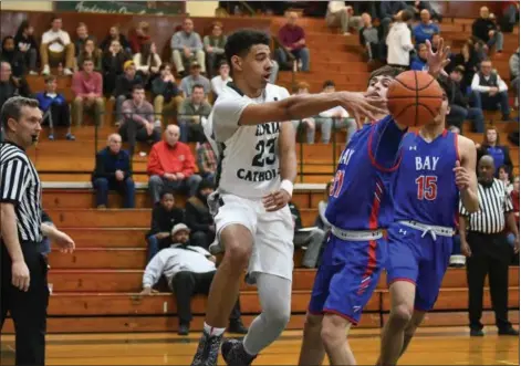  ?? ERIC BONZAR — THE MORNING JOURNAL FILE ?? Elyria Catholic’s Jarred Logan passes around Bay point guard Christian Dupps. With the graduation of Dorian Crutcher, Logan will be relied on to lead the Panthers.