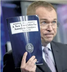  ?? ANDREW HARNIK/AP PHOTO ?? Budget Director Mick Mulvaney holds up a copy of President Donald Trump’s proposed fiscal 2018 federal budget as he speaks to members of the media in the Press Briefing Room of the White House in Washington, Tuesday.