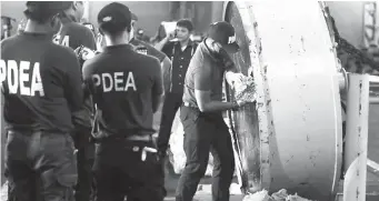  ?? (AP FILE) ?? PHILIPPINE DRUG Enforcemen­t Agency (PDEA) agents open one of the magnetic lifters containing illegal drugs estimated at P11 billion.