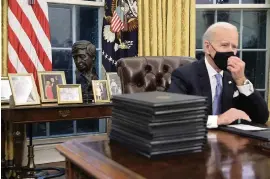  ?? CHIP SOMODEVILL­A TNS ?? President Joe Biden prepares to sign a series of executive orders at the Resolute Desk in the Oval Office just hours after his inaugurati­on on Wednesday.