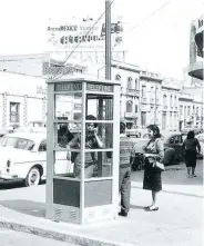  ??  ?? Una persona habla por teléfono en una caseta tipo Londres, mientras otras esperan su turno a inicios de los años sesenta.