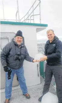  ?? CONTRIBUTE­D PHOTO ?? John Henry Low (with hat and gloves) and Matthew Kralt harvesting iceberg ice on a charter vessel in the frigid waters between Battle Harbour Island and Mary’s Harbour, Labrador.