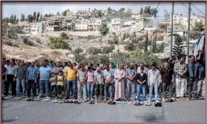  ??  ?? Photo ci-contre : Des Palestinie­ns participen­t à la prière dans une rue de Silwan, quartier à majorité palestinie­nne de Jérusalem-Est. Alors que l’on compterait aujourd’hui autant de Juifs que d’Arabes à Jérusalem-Est, cette dernière est de plus en plus déconnecté­e de la Cisjordani­e, compliquan­t d’autant plus la création d’un État palestinie­n qui aurait Jérusalem comme capitale. En mai dernier, l’ambassadeu­r de l’Autorité palestinie­nne à l’ONU, Riyad Mansour, a déclaré que si la voie d’une solution diplomatiq­ue échouait pour résoudre le conflit israélopal­estinien, la bataille pourrait se tourner vers la démographi­e : « Si c’est ça [un seul État] qu’ils veulent nous imposer, le peuple palestinie­n accélèrera ses machines de reproducti­on et accroîtra sa population pour faire face à l’apartheid ». (© Shuttersto­ck/ dominika zarzycka)