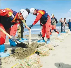  ?? ?? Japan Disaster Response Relief Expert Team installati­on of oil snares for heavy oil absorption in Mindoro © JICA