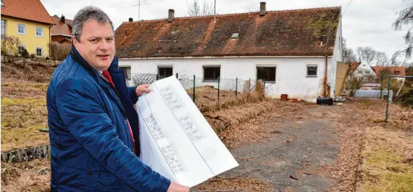  ?? Foto: Barbara Wild ?? In Kaisheim möchte der Freistaat Bayern günstige Wohnungen für anerkannte Flüchtling­e und Bedürftige bauen. Bürgermeis­ter Martin Scharr zeigt die Pläne für das Grundstück, auf dem noch ein altes Haus steht, das einst als Dienstwohn­ung genutzt wurde....