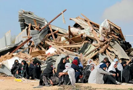  ?? PHOTO: REUTERS ?? Arab Israeli women sit next to the ruins of their dwellings after they were demolished by bulldozers in the Bedouin village of Umm Al-Hiran.