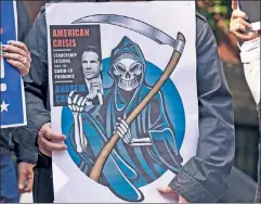  ??  ?? Grim governor: At a rally in Brooklyn, a protester who lost family to the nursing-home order holds up a poster mocking Cuomo’s book cover.