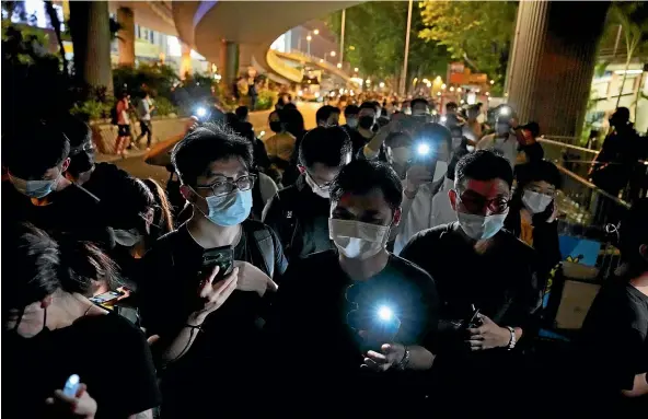  ?? AP ?? People light LED candles to mark the anniversar­y of the military crackdown on a pro-democracy student movement in Beijing, outside Victoria Park in Hong Kong.