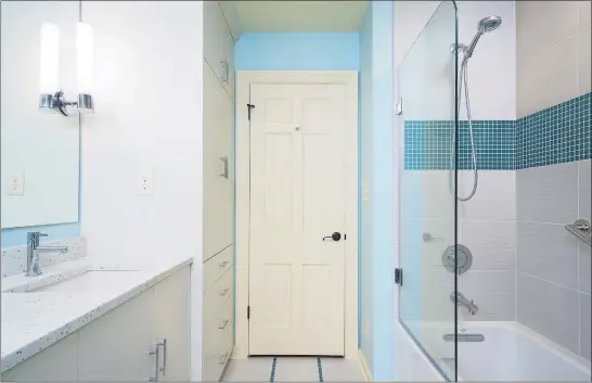  ?? [CLEARY CO.] ?? This bathroom has a glass shower enclosure, a connected color scheme, lots of lighting and a big mirror to make the most of its tight space.
