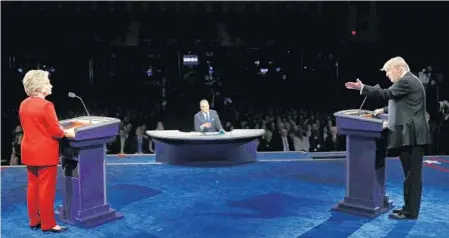  ?? JOE RAEDLE/GETTY IMAGES ?? Democratic presidenti­al nominee Hillary Clinton listens as Republican candidate Donald Trump makes a point during Monday’s debate at Hofstra University in Hempstead, N.Y. It was the first of four scheduled between the two candidates, who fielded...