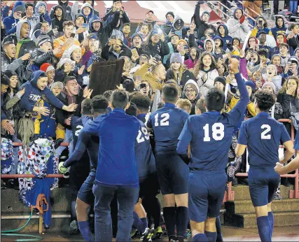  ?? SUZANNE TENNANT/POST-TRIBUNE ?? The Bishop Noll boys soccer team bring the state championsh­ip trophy to the fans after winning the Class 2A state final 1-0 against Indianapol­is Ritter on Friday.